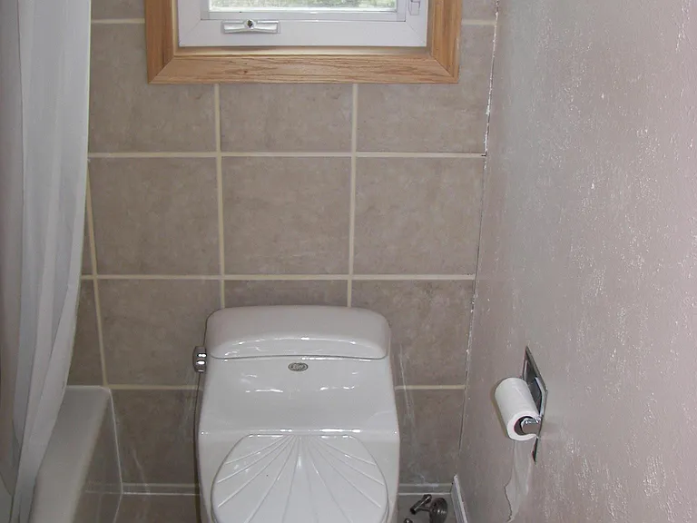 Second Bathroom, view of toilet with edge of modern 6' tub s