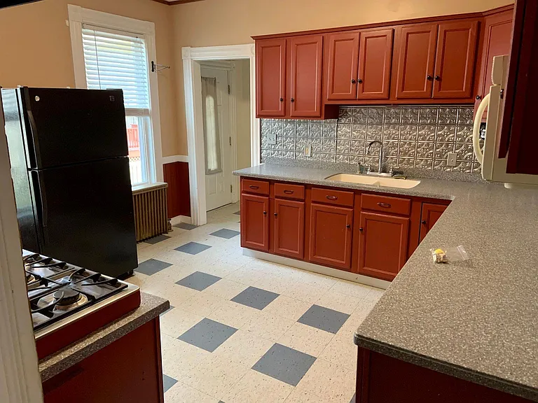 Large Kitchen with a separate entry way and behind that a full bathroom with shower.