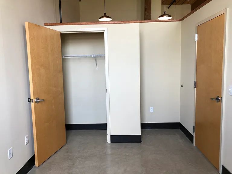 Bedroom closet space and a nook for a dresser.