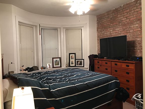 Master bedroom with two walls of exposed brick and huge clos