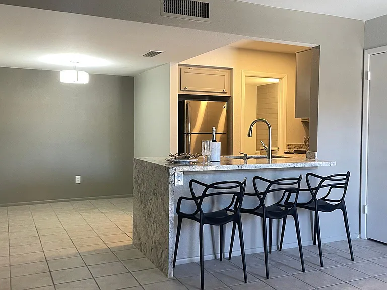 Kitchen with waterfall effect countertop, closet on the right side, dining area on the left side. Room for a square, round or rectangular table.