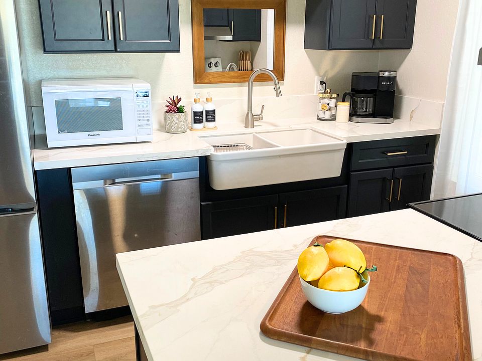 Kitchen with farmhouse sink, microwave, new cabinets, countertops, dishwasher, Keurig duo coffee maker.