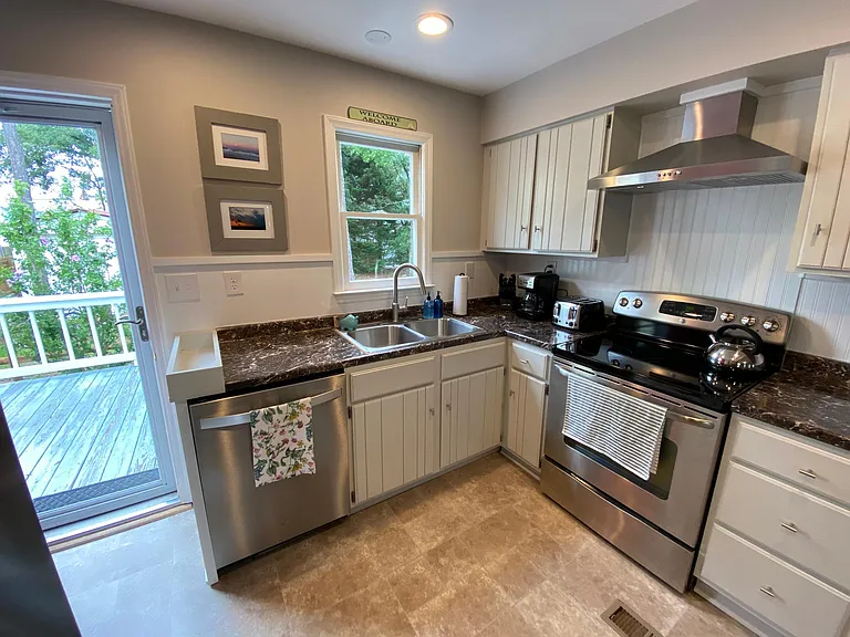 Kitchen leads to the back deck, where the grill is located