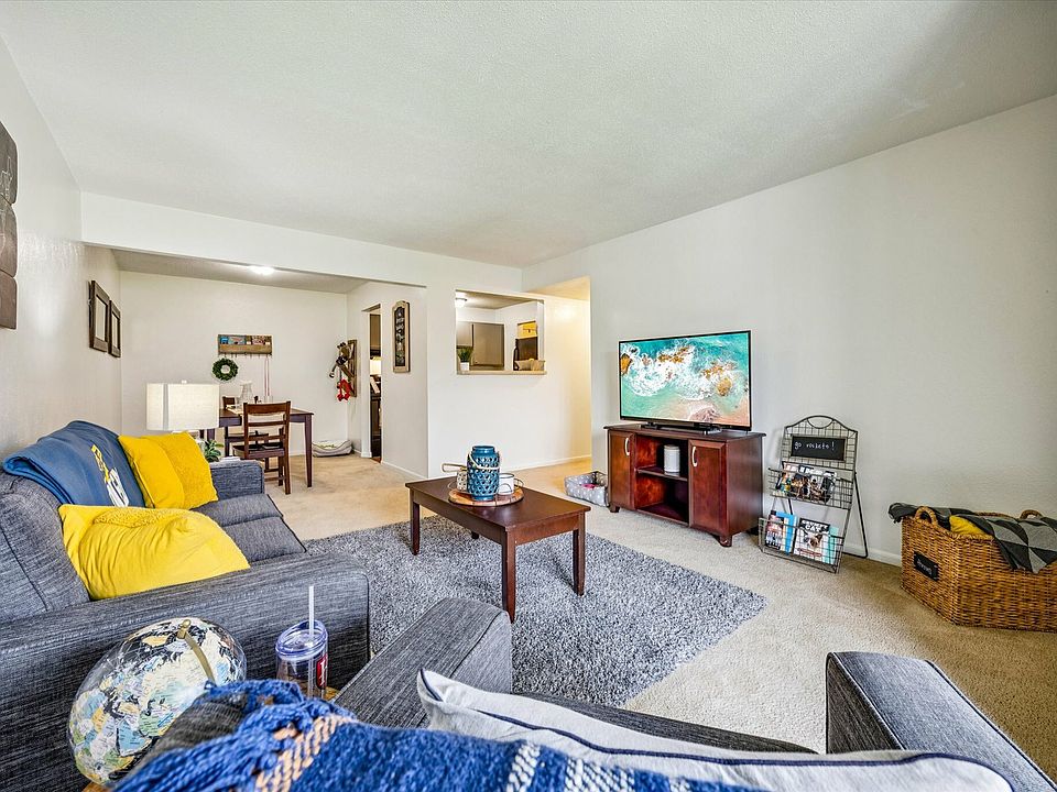 Relax in a stylish, comfortable living room with open layout and modern furnishings at University Hills Apartments.