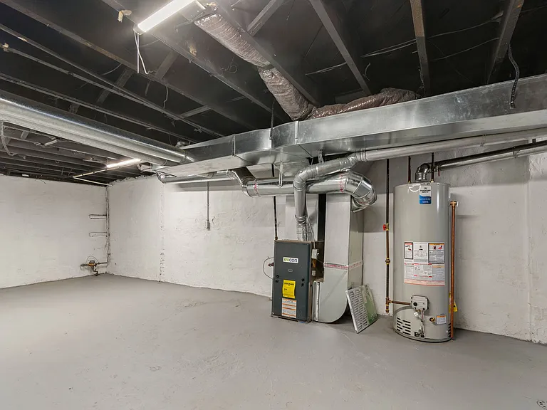 Basement with washer, dryer and laundry sink.