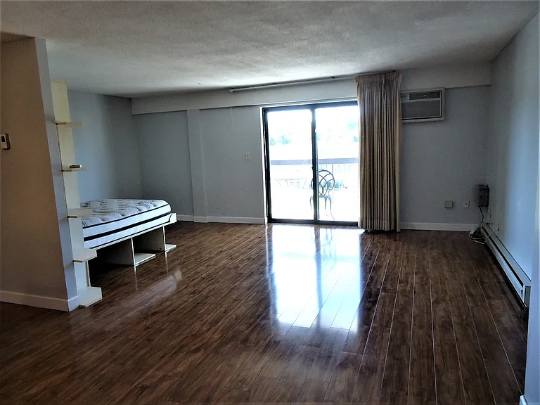 Dining area in foreground, living/office/Murphy bed/balcony area