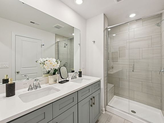 The primary bathroom boasts a dual-sink vanity and spacious walk-in shower.