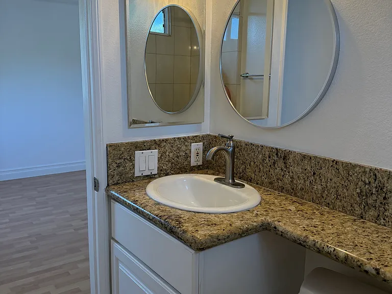 BATHROOM HAS LARGE GRANITE COUNTERTOP