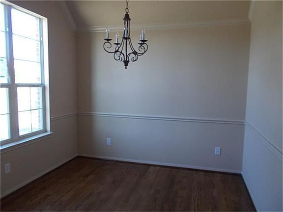 Light & bright study or multi-purpose are with crown molding, wrought iron chandlier & wood floor.