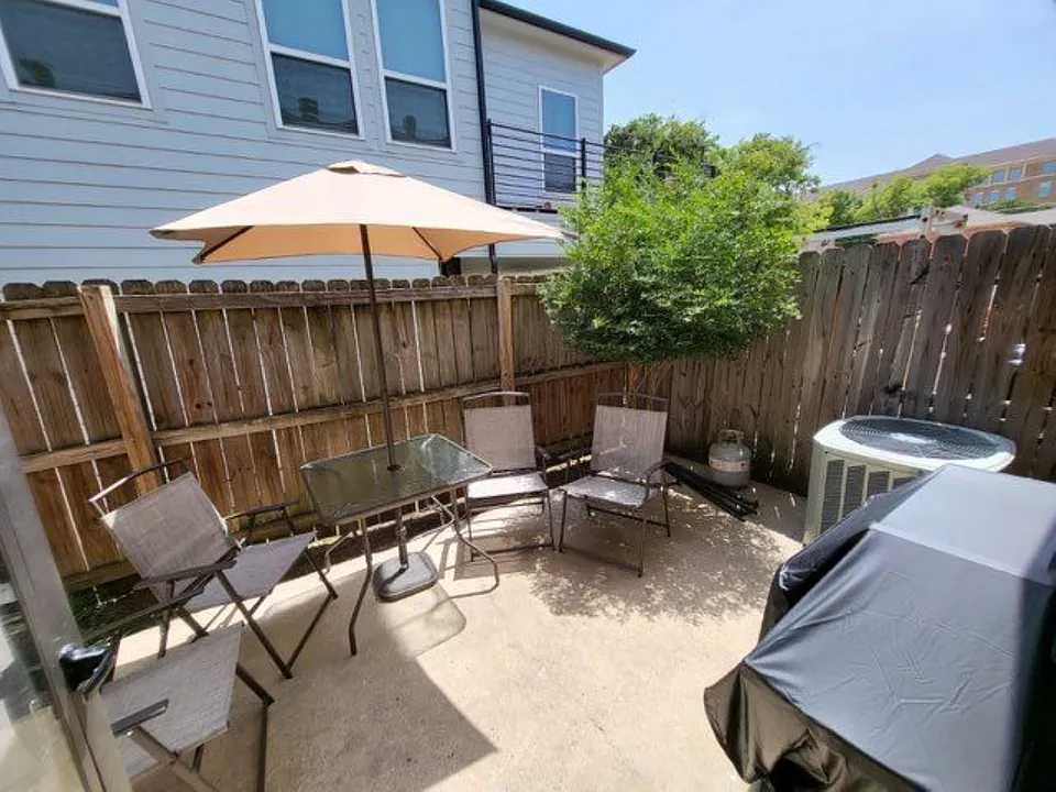 Private fenced patio featuring a concrete slab and natural wood fencing