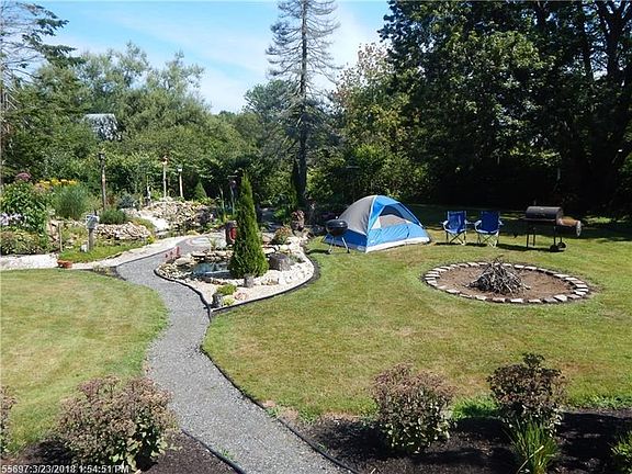 Meticulously maintained yard with two ponds with pumps and a fire pit.