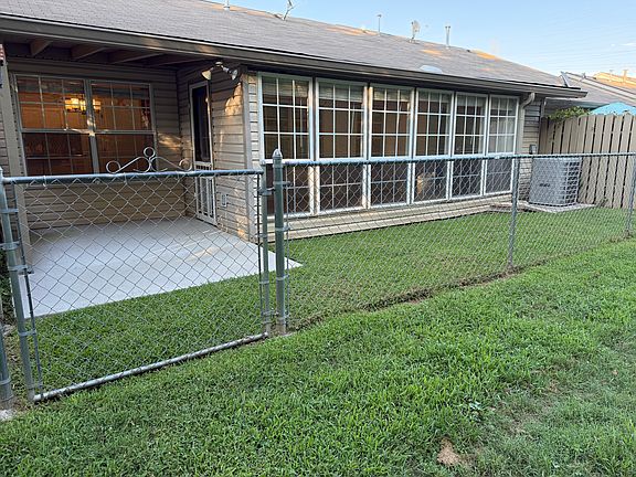 Backyard looking at covered patio and sunroom windows.