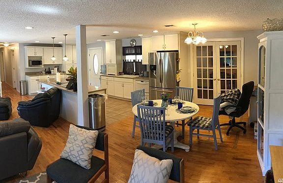 Open concept living area with a cozy den behind the double doors.