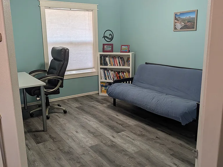 Open office off the living room with futon, desk, and office chair