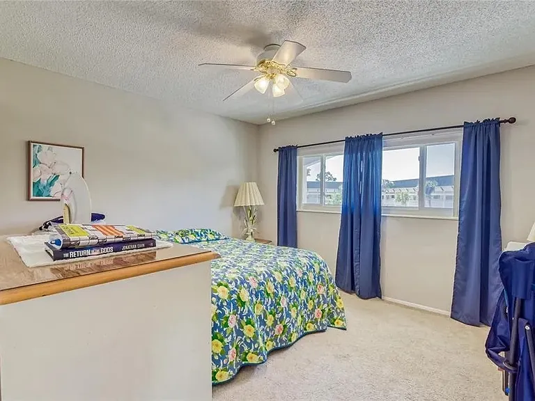 Guest bedroom with ceiling fan and closet space.

 *This unit is unfurnished. All furniture has been removed.