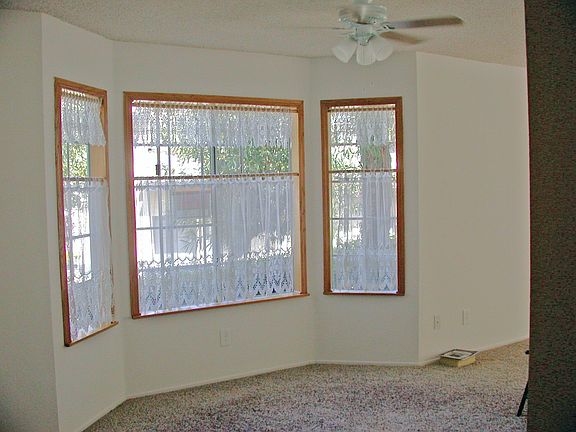 dining area features bow window and ceiling fan