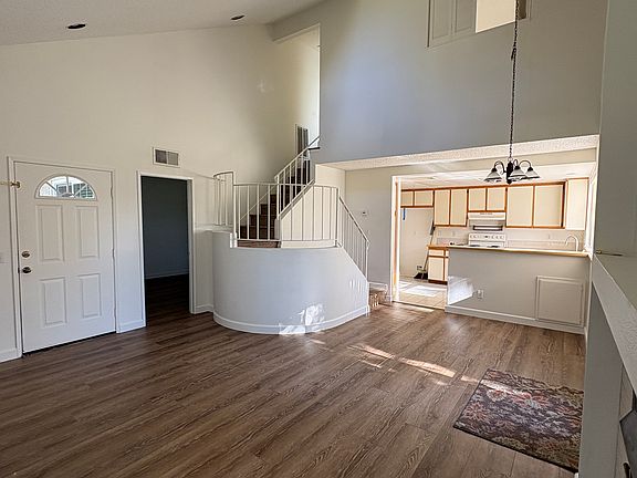 living area looking back to kitchen and stairs to upstairs bed and bath. doorway leads to downstairs bedroom