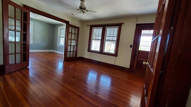 Living room into dining room through french doors (or a 4th bedroom). Front door leads to balcony.