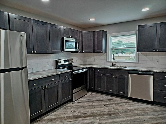 Granite countertops with plenty of high end cabinets and bright lighting.