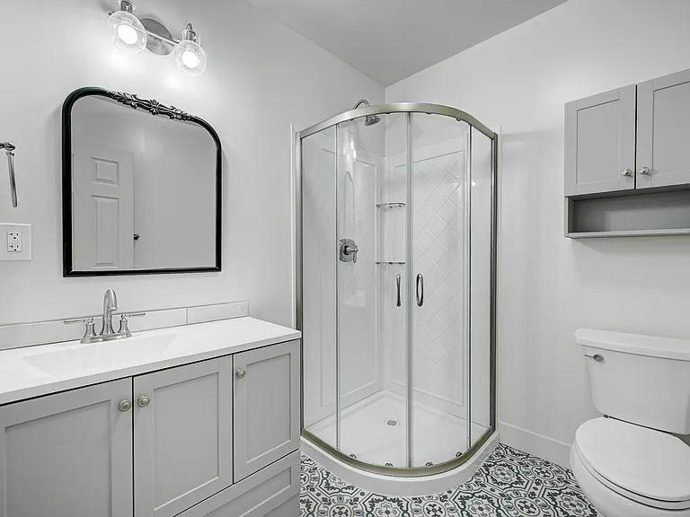 Brand new spacious 3/4 bath on the main level features a neo-curved shower and all new vanity, flooring, commode and storage!