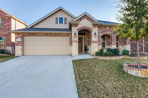 A deep covered porch with upgraded coach lighting and custom wood stained front door