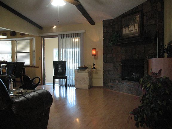Living room offers a wood burning gas fire place with glass doors and a rustic mantel.