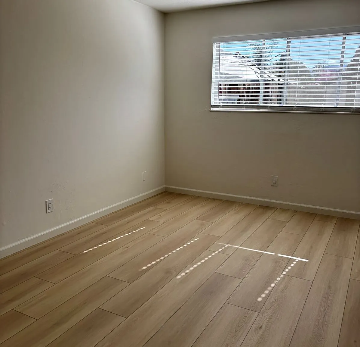 A generously sized bedroom with mirrored closet doors that add brightness and a sense of expanded space.