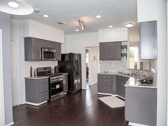 To the left of the entry is the completely remolded kitchen, complete with granite, brand new stainless steel appliances, track lighting and breakfast area.(black refridgerator will be removed)