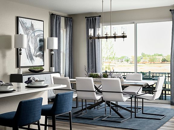 A modern and stylish dining room with a large window overlooking a scenic outdoor area, featuring a