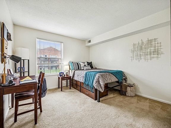 Relax in a cozy bedroom with a study space and modern decor at University Hills Apartments near the University of Toledo.