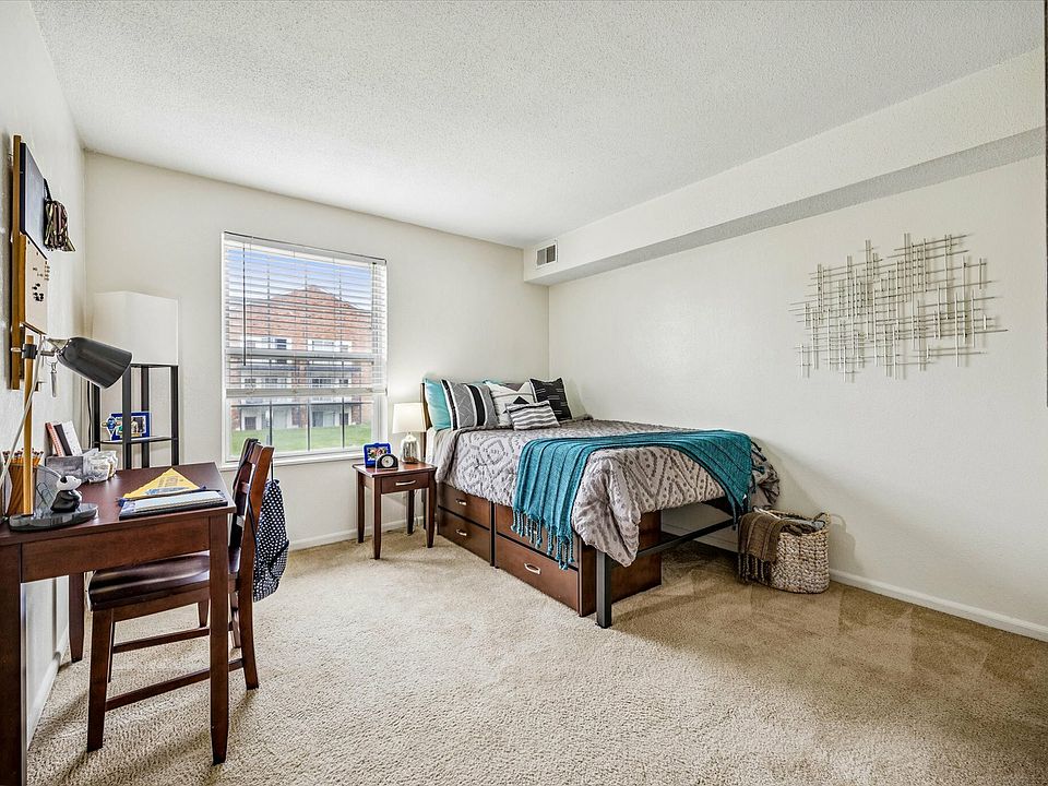 Relax in a cozy bedroom with a study space and modern decor at University Hills Apartments near the University of Toledo.