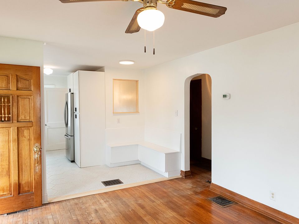 Open plan layout from living room looking into kitchen nook and hallway leading to the bathroom and both bedrooms.