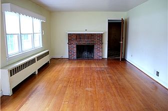 Hardwood floors & brick fireplace in living room