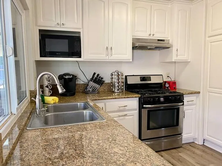 Fully equiped Kitchen with stainless steel dishwasher and stove.