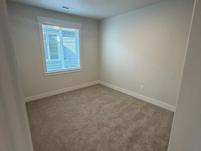 Bright and inviting, the second bedroom boasts an east-facing window that captures natural morning light and a spacious closet offering plenty of storage. Its versatile layout makes it ideal for a bedroom, guest room, or workspace.