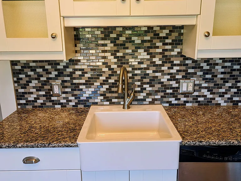 Large, eat in kitchen with granite counters, stainless steel appliances, mosaic tile backsplash, undercabinet lighting and lots of natural light.