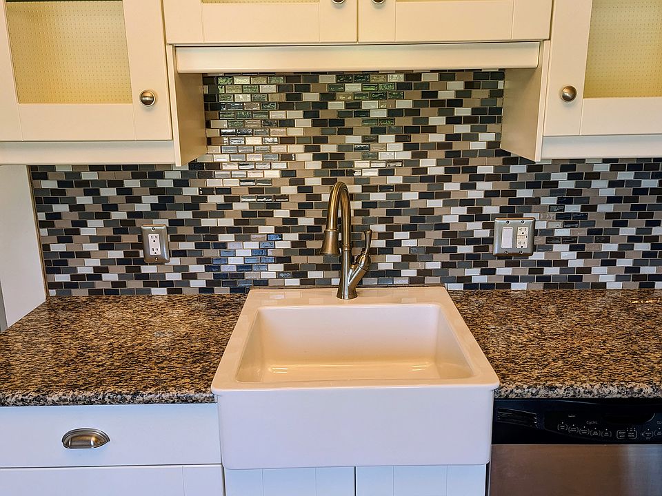 Large, eat in kitchen with granite counters, stainless steel appliances, mosaic tile backsplash, undercabinet lighting and lots of natural light.