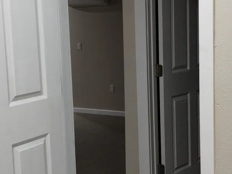 View from the back room out to the hallway, room in front of it, and dining area