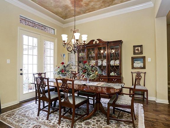 Large formal dining room with double French doors to the patio, custom ceiling treatment, wood floors and beautiful wood moldings! A great room for intimate dinners or large gatherings!