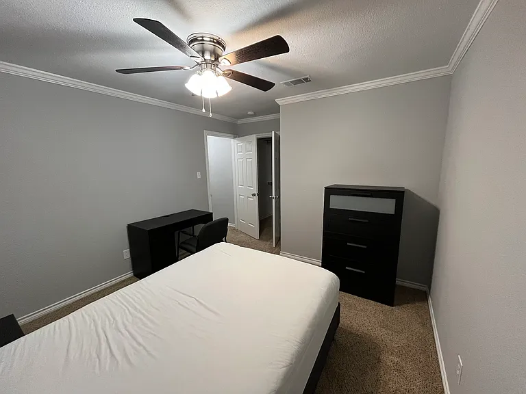 Secondary Bedroom #1, furnished with full size bed, tall dresser, desk, chair, & nightstand. Walk in closet. Private space for occupant of secondary bedroom #1.
