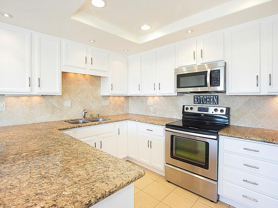 Kitchen with under cabinet lights and granite counters.