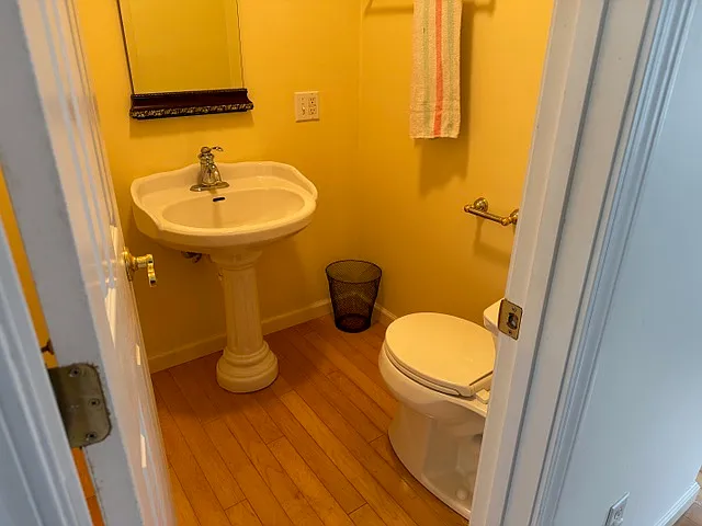 Guest half bathroom next to living room and front door.