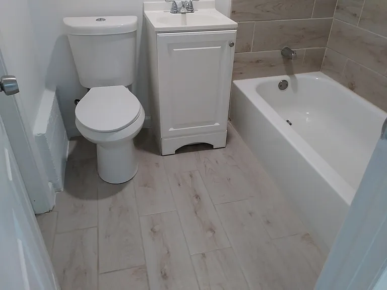 Custom Bathroom with tiled floor and shower and deep metal tub