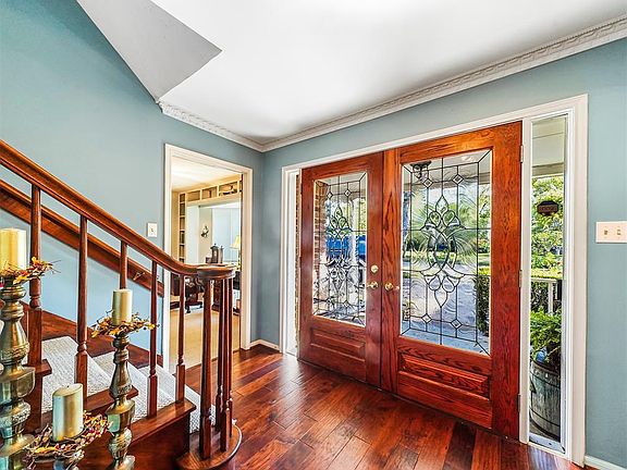 The entry is spacious and welcoming with rich hardwood flooring, crown molding and gorgeous natural light that streams through t