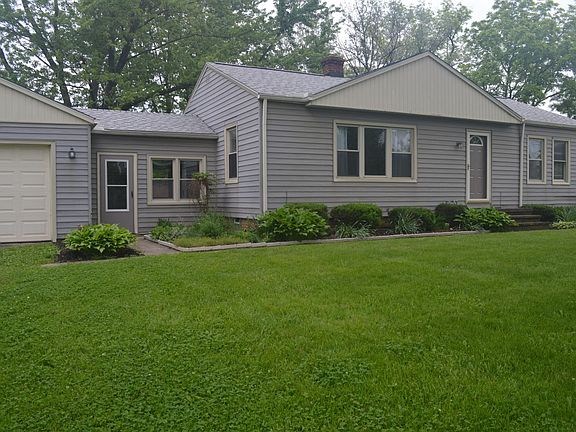 Close-up, front-view of house. Patio room connecting house and 2-car garage.