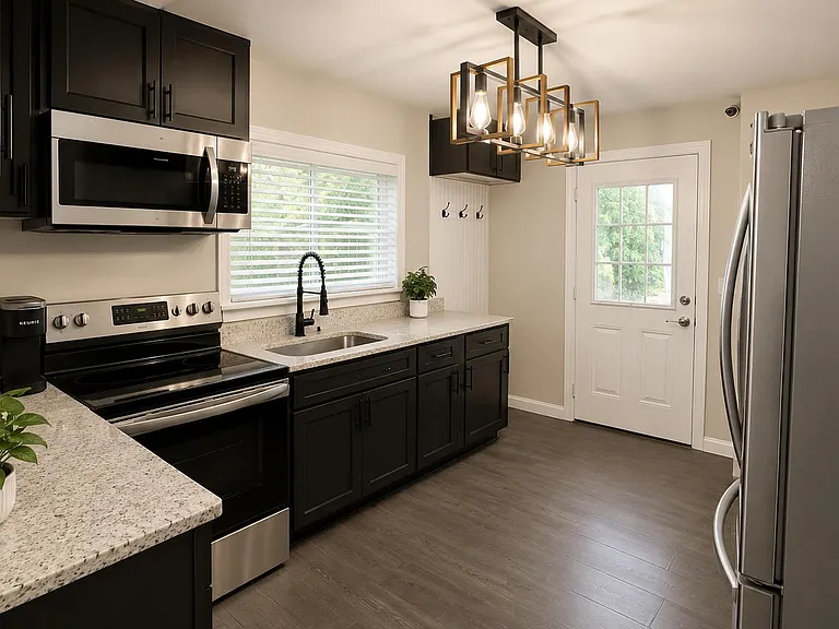 Updated kitchen with granite-look counters, black cabinetry, stainless appliances, and a sink under a window.