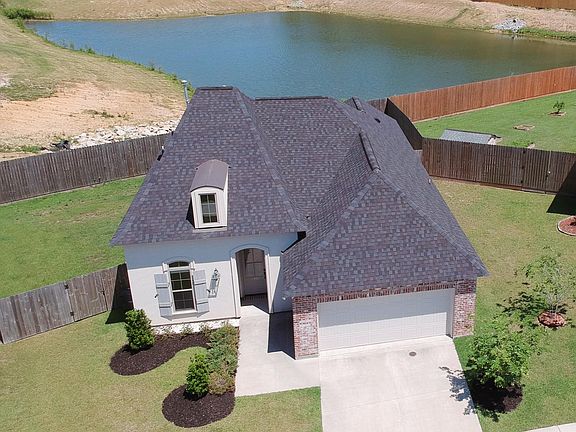 Aerial view of home, showing the calm pond behind home