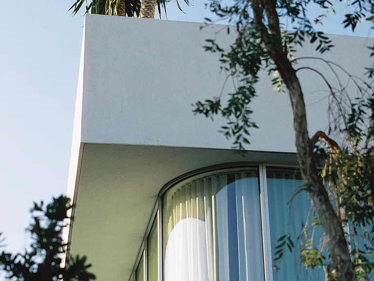 Curved Glass Softens Its Presence - A striking architectural masterpiece, Asteras Kings seamlessly blends contemporary design with nature.