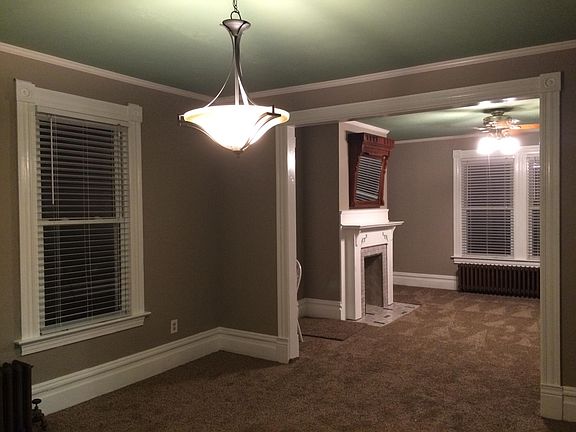 View from the dining room to the living room. Note the ceiling fan and light fixture.