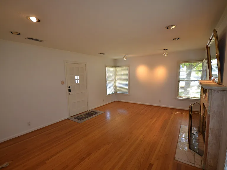 Living area featuring wood-finish flooring, recessed lighting, and a front entry door with glass paneling.